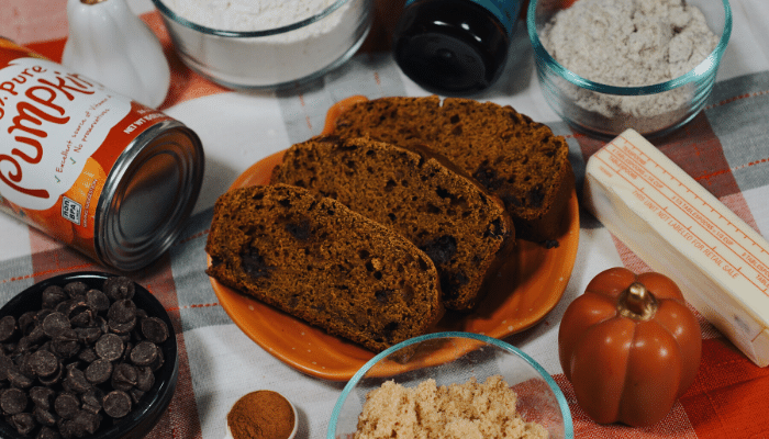Pumpkin Spice protein bread on table surrounded by ingredients 