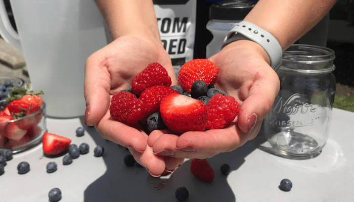 Woman holding strawberrys and blueberrys