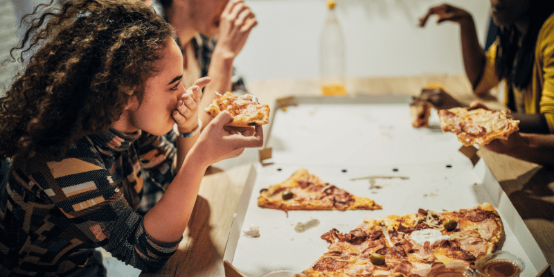 Fit people enjoying a meal of pizza together